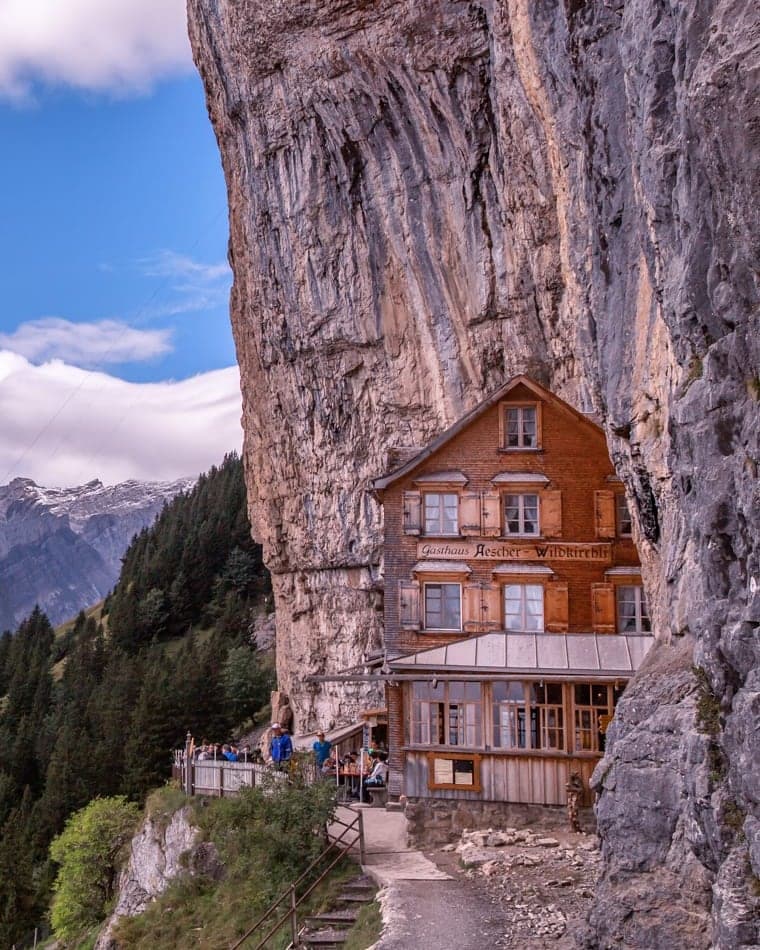 Berggasthaus Äscher-Wildkirchli unter der Felswand der Ebenalp mit Blick in den Alpstein, Appenzell Innerrhoden
